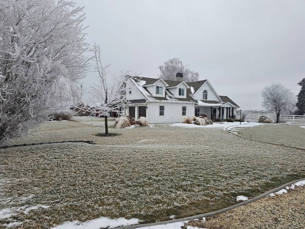 White ASCEND composite board and batten farmhouse with white soffit and fascia on a frosty Idaho winter day