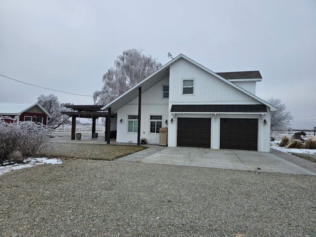 White ASCEND composite board and batten siding with a deep white aluminum soffit overhang over a covered patio and two-car garage